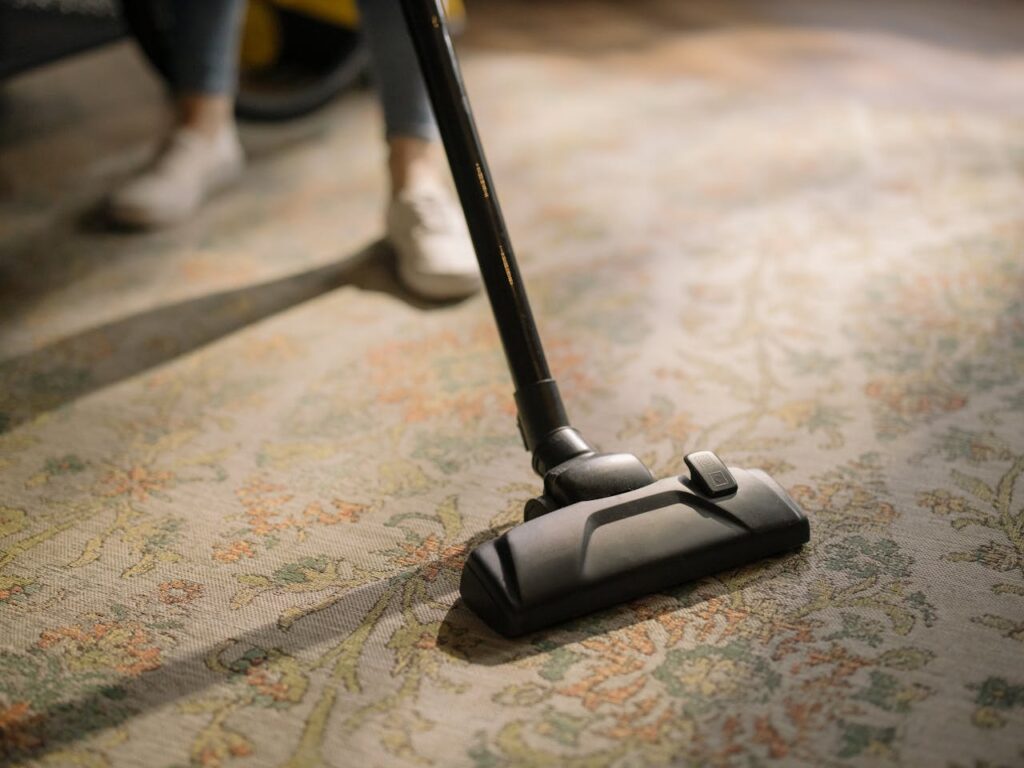 Mastering the First Impression: Your intriguing post title goes here Close-up of a vacuum cleaner on a patterned carpet in a sunlit room, capturing a moment of household cleaning.
